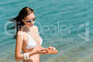 Summer young woman with suncream in bikini