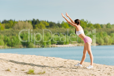 Summer sport active woman stretching on beach