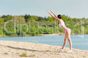 Summer sport active woman stretching on beach