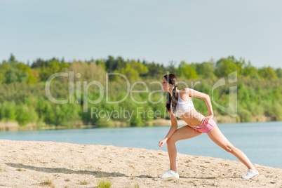 Summer sport fit woman stretching on beach