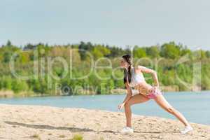 Summer sport fit woman stretching on beach