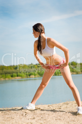 Summer sport fit woman stretching on beach