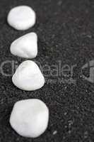Weisse Steine auf schwarzem Sand