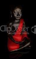 Schwarzer Buddha mit rotem Umhang bei Nacht