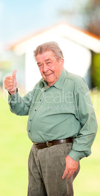 Senior steht glücklich vor seinem Haus im Garten