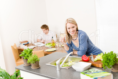 Happy woman cook enjoy wine in kitchen