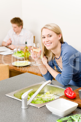 Happy woman kitchen cook enjoy white wine