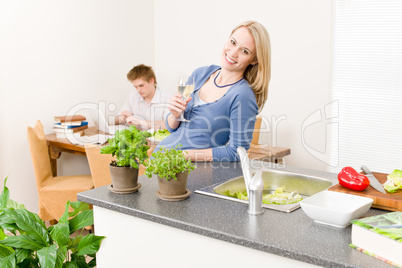 Happy woman cook enjoy white wine in kitchen