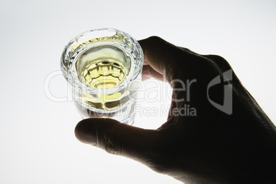 Hand around shot glass of liquor