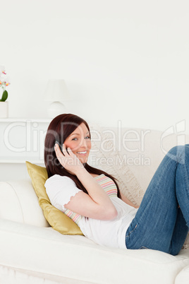 Attractive red-haired woman having a conversation on the phone w