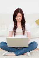 Good looking woman relaxing with her laptop while siting on a ca