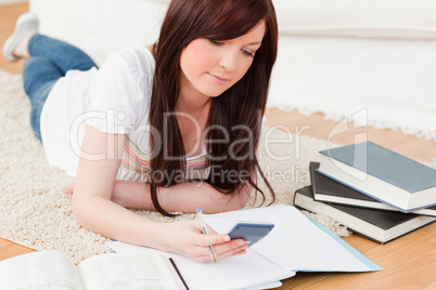 Good looking red-haired female studying for while lying on a car