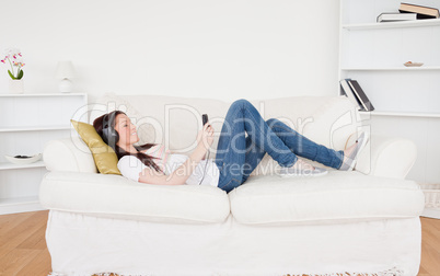 Attractive red-haired female listening to music with headphones