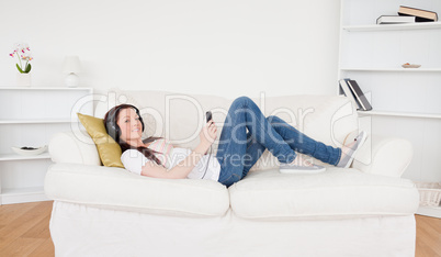 Beautiful red-haired female listening to music with headphones w