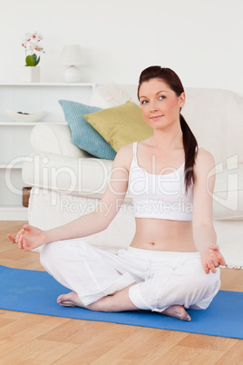 Good looking woman doing yoga on a gym carpet