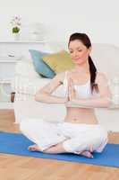 Pretty woman doing yoga on a gym carpet