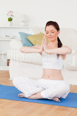 Attractive female doing yoga on a gym carpet