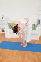 Pretty red-haired female stretching in the living room