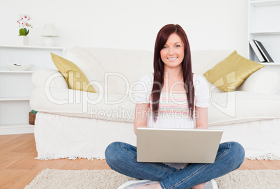 Attractive female relaxing with her laptop while siting on a car
