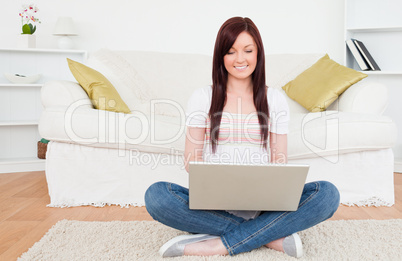 Beautiful female relaxing with her laptop while siting on a carp