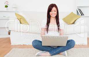 Beautiful female relaxing with her laptop while siting on a carp