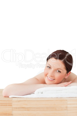 Smiling red-haired woman posing while relaxing in a spa centre