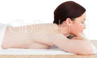 Young attractive red-haired woman posing while relaxing in a spa