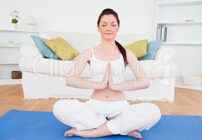 Attractive female doing yoga on a gym carpet