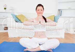 Cute female doing yoga on a gym carpet