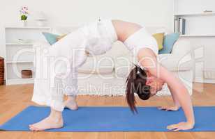 Pretty red-haired female stretching in the living room