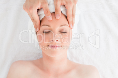 Closeup of a young gorgeous red-haired woman receiving a massage