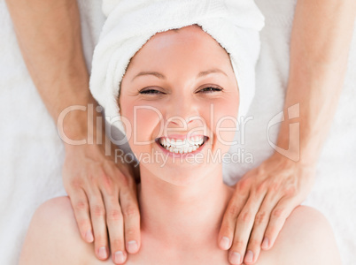 Closeup of a charming red-haired woman receiving a massage in a