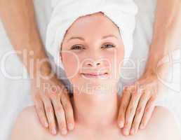 Closeup of a cute red-haired woman receiving a massage in a spa