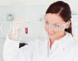Pretty scientist looking at a test tube in a lab
