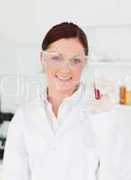 Smiling scientist looking at the camera while holding a  test tu