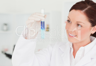 Smiling red-haired scientist looking at the camera while holding