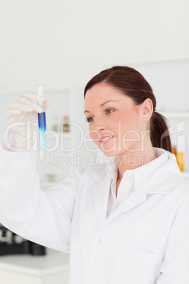 Attractive red-haired scientist looking at the camera while hold