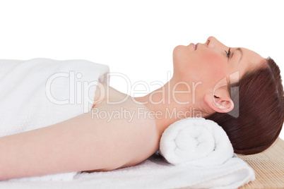 Closeup of a cute serene woman posing while relaxing in a spa ce