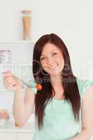 Beautiful red-haired woman cutting eating a cherry tomato in the