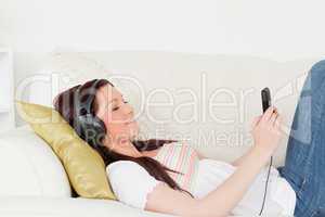 Attractive red-haired woman listening to music with headphones w