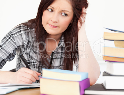 Attractive red-haired girl studying for an examination