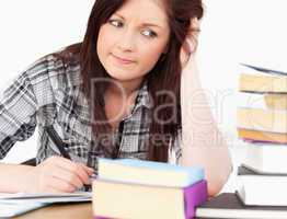 Attractive red-haired girl studying for an examination