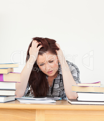 Attractive red-haired female being depressed while studying for