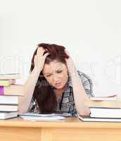 Attractive red-haired female being depressed while studying for
