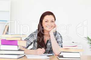 Good looking joyful red-haired girl studying for an examination