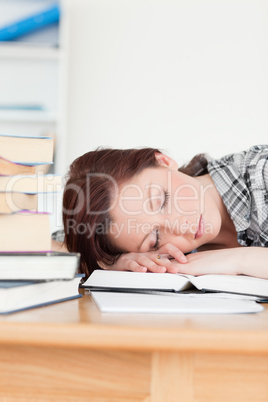 Attractive red-haired girl having a rest while studying for an e
