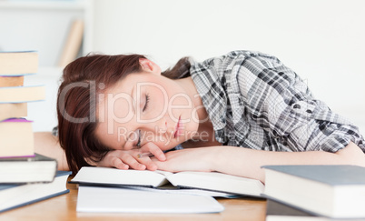 Good looking red-haired girl having a rest while studying for an