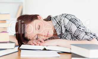 Good looking red-haired girl having a rest while studying for an