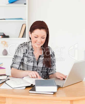 Gorgeous red-haired girl relaxing with a laptop