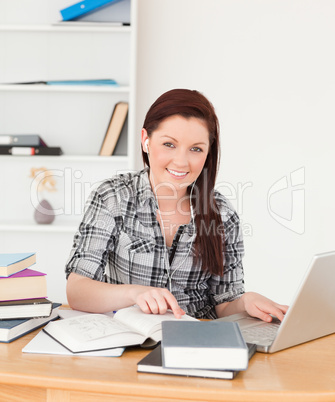 Young beautiful red-haired girl relaxing with a laptop